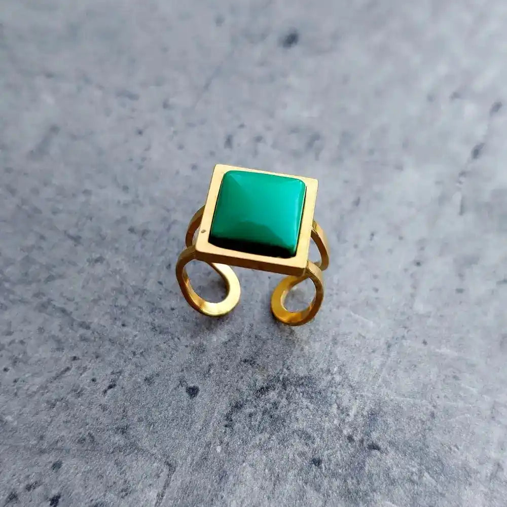 podesivi prsten jednostavnog dizajna od hirurškog celika sa detaljem u zelenoj boji.